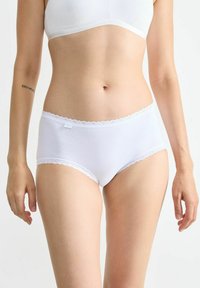 Weiße Baumwollunterhose mit Spitzenbesatz am Bund. Glatte Textur, mittlere Leibhöhe, minimale Markenkennzeichnung auf der Vorderseite.