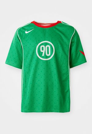 Zelena Nike sportska majica kratkih rukava, s bijelim detaljima, uzorkom s točkicama i kružnim bijelim logotipom "90" u središtu. Crvena ovratnik.