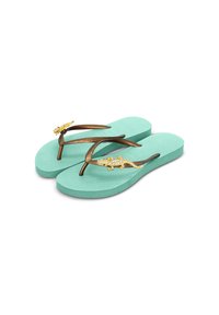 Des tongs avec une semelle vert menthe, des sangles métalliques marron ornées de lézards dorés décoratifs embellis de strass sur le dessus.