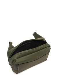 Borsa verde oliva realizzata in materiali lisci e testurizzati, con un compartimento principale con zip e un design strutturato.