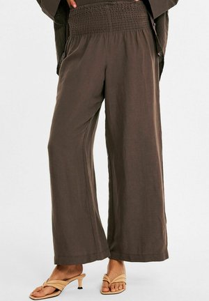 Braune weite Hosen mit smocktem Bund, aus leichtem Stoff gefertigt. Sie bieten einen lockeren Schnitt und einen nahtlosen Saum am Ende für zusätzlichen Komfort.