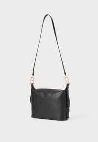 Sac en cuir noir porté en bandoulière avec une texture lisse, de forme rectangulaire, des accents en métal doré et une sangle réglable. Fermeture zippée.
