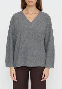Maglione grigio lavorato a maglia con scollo a V, vestibilità rilassata e maniche lunghe, impreziosito da sottili scintillii distribuiti su tutto il tessuto.