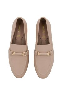 Mocassini in pelle beige con texture liscia, caratterizzati da un dettaglio hardware color oro, con punta arrotondata e cuciture lungo i bordi.