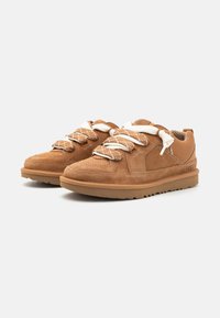 Baskets en daim marron avec des accents en mesh, présentant de solides lacets blancs et des semelles texturées pour une meilleure traction. Bout arrondi et côtés rembourrés.
