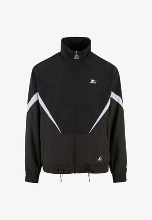 Schwarze Jacke mit hohem Kragen, Frontreißverschluss und elastischen Bündchen. Verfügt über weiße diagonale Streifen und ein kleines Logo auf der Brust. Die Textur ist glatt.