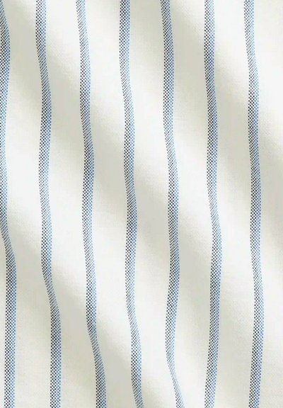 Échantillon de tissu présentant un matériau blanc avec des rayures verticales alternées en bleu et bleu foncé, texture lisse et léger éclat.