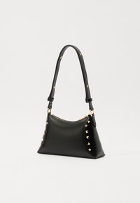 Black handbag made of smooth leather, featuring gold-tone studs and hardware, a single shoulder strap, and a zip closure.