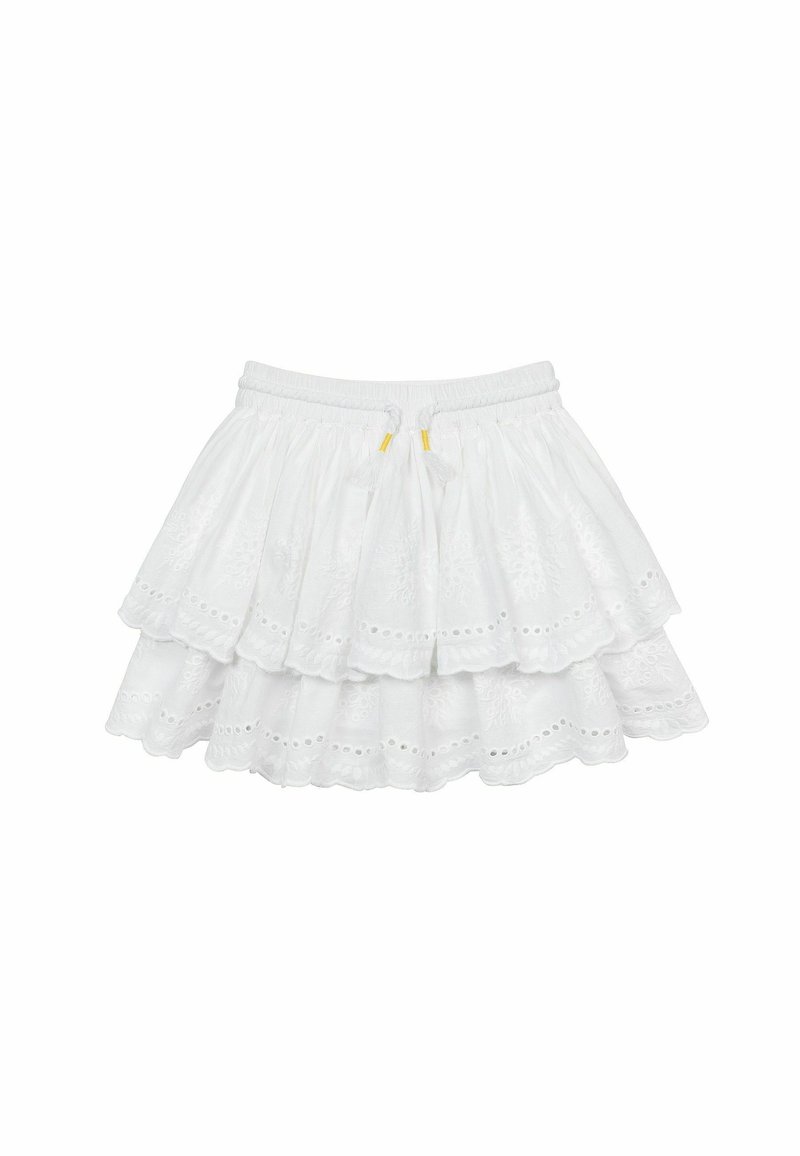 Jupe blanche à étages avec une ceinture élastique, ornée de broderies décoratives, de détails en œillets et deux pompons jaunes à l'avant.