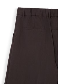Pantaloni in lino marroni con cintura elastica, tasche laterali e due tasche posteriori, dotati di una finitura semplice e testurizzata.