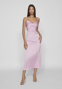 Satinrosa midiklänning med draperad urringning, tunna band och slät textur, kombinerad med gyllene remsandaler.