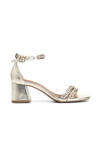 Kulta metalliset korkokengät, joissa on lohkokorko, koristeellinen nilkkahihna pyöreillä jalokivikoristeilla ja kaksi etuhihnaa.