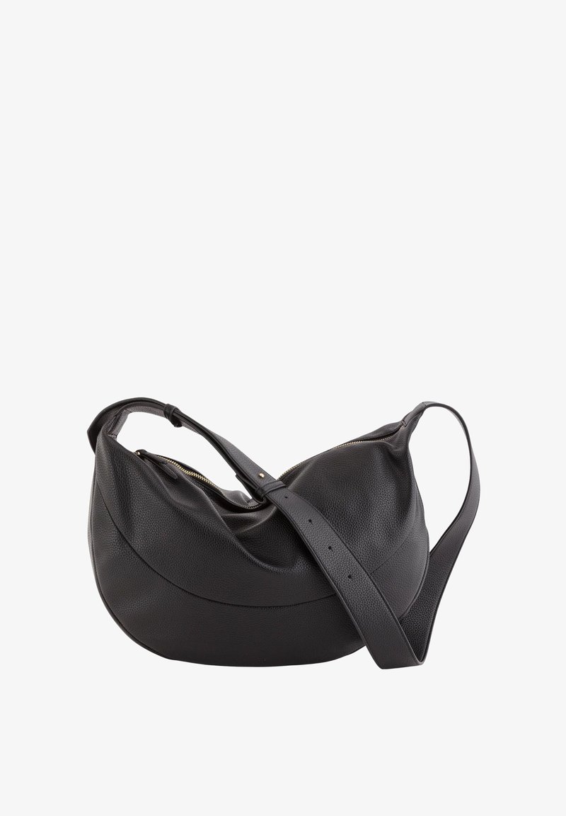 Bolso de hombro de cuero negro con forma curva, superficie texturizada y una correa larga. Cuenta con cierre de cremallera y detalles mínimos de herrajes dorados.