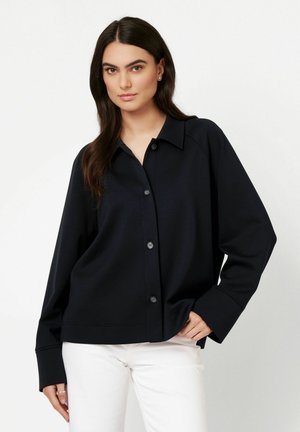 Navy button-up shirt with a collar, long sleeves, and a relaxed fit. Fabric appears smooth with a light sheen; buttons are dark.