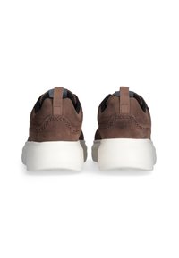 Brązowe zamszowe sneakersy z białą podeszwą, z kontrastującą czarną wyściółką i tylnym uchwytem do łatwego zakładania. Obecne dekoracyjne przeszycia.