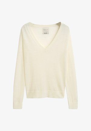 White V-neck sweater made of soft wool. Features long sleeves, ribbed cuffs, and a straight hem. Minimalist design with no patterns or accents.