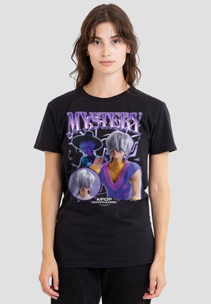 Young woman wearing black T-shirt featuring purple "MYSTERY" text and Kpop Demon Hunters anime-style character with silver hair and purple vest.