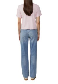 Helles rosa kurzärmliges, cropped T-Shirt, kombiniert mit hellblauen, locker sitzenden Jeans, die ein klassisches Fünf-Taschen-Design und dezente Verblassungen aufweisen.