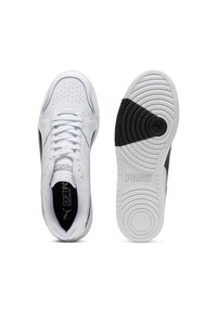 Weiße Sportschuhe mit schwarzen Akzenten, oberer Teil aus glattem Leder, perforierte Zehenpartie, gepolsterte Sohle und auffälliges Puma-Branding auf der Zunge und der Außensohle.