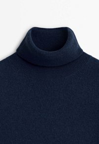 Pull à col roulé côtelé bleu marine avec un col replié et une texture douce.