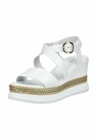 Hvide kile sandaler med krydsede remme, en spænde og en struktureret guldaccent på platformen. Glat materiale, minimalistisk design.