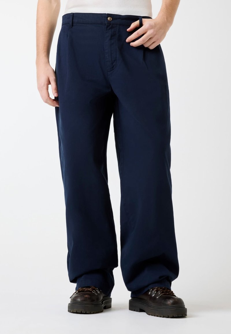 Marineblaue Hose aus einem einfarbigen, glatten Stoff. Verfügt über einen Knopfverschluss, Fronttaschen und eine lockere Passform mit geraden Beinen.