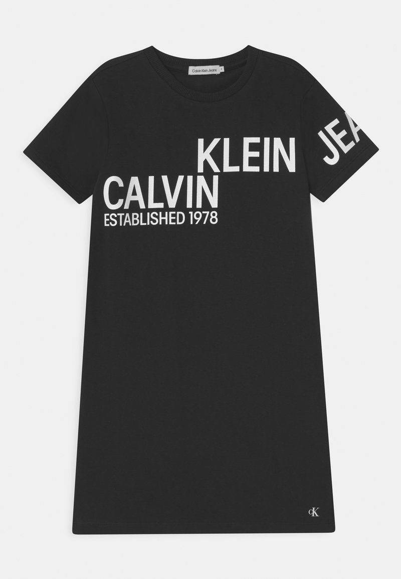 Černé bavlněné tričko s výrazným bílým textem: "CALVIN KLEIN JEANS ZALOŽENO 1978." Kulatý výstřih a krátké rukávy, s logem.