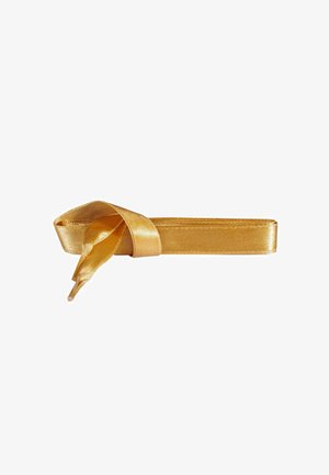 Kultainen satiininauha, joka on solmittu löysään solmuun, sisältäen sileän tekstuurin ja kiiltävän pinnan, kapeneva molemmista päistä, ihanteellinen lahjapakkauksiin tai koristeluun.