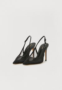 Cizme negre cu toc slingback, cu vârful ascuțit, realizate din plasă și piele. Prezintă un toc subțire și o curea ajustabilă pentru o fixare sigură.
