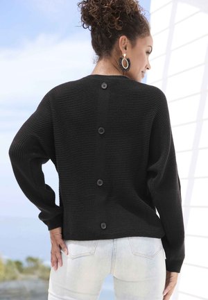 Schwarzer gerippter Strickpullover mit lockerer Passform und Knopfdetails entlang des Rückens. Mit langen Ärmeln und einer strukturierten Oberfläche.