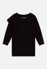 Sweatshirt noir avec un accent froncé sur une épaule, manches longues et encolure arrondie. Il présente un ourlet droit et un logo au dos.