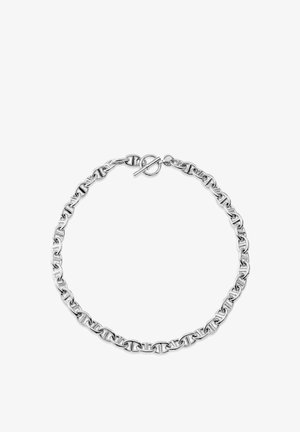 Sølvkæde med sammenlåste led og en låsespænde, arrangeret i en cirkel på en hvid baggrund.