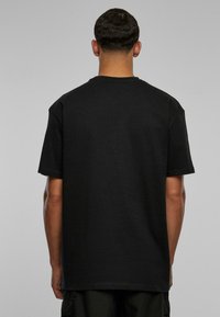 Sort kortærmet T-shirt lavet af bomuld, med en klassisk rund hals og en afslappet pasform, der har en glat overflade og et minimalistisk design.
