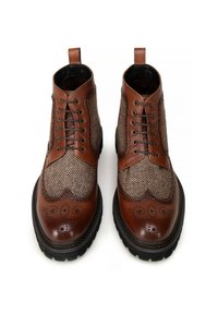 Hnědé kožené ankle boots s tkaninou s herringbone vzorem, kulatou perforovanou špičkou, šněrováním a texturovanou podrážkou s vzorovými akcenty.