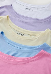 Trička s krátkými rukávy v růžové, modré, žluté, levandulové a bílé bavlně. Mají kulaté výstřihy a viditelnou značku "NEXT".