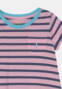 Koszulka krótki rękaw w paski w kolorze różowym i granatowym, z turkusowym okrągłym dekoltem i kieszonką. Posiada małe haftowane logo nad kieszonką.