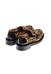 Schoen met luipaardpatroon en glanzende zwarte lakleren accenten, ronde neus en een dikke zwarte zool. Dubbele banden sieren de wreef.