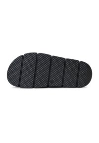 Semelle de chaussure noire segmentée avec motif texturé en losange, plate sur fond blanc, montrant le dessin de la bande de roulement et les sections de flexibilité.