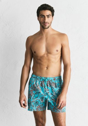 Türkisfarbene Badeshorts mit Korallen- und Meereslebewesen-Mustern, Kordelzug am Bund, aus leichtem Stoff gefertigt, mit lockerem Schnitt.