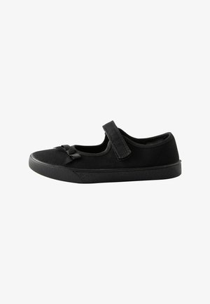 Chaussure Mary Jane noire pour enfants avec une bride auto-agrippante et un petit nœud décoratif sur l'avant-pied sur fond blanc.