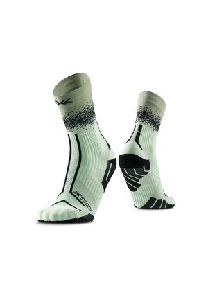 Lichtgrijze sportsokken met zwarte zolen met grip patroon en zwart gespetterd ontwerp rond de enkel, getoond van voren en van achteren.