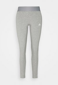 Grå träningsleggings med en bred grå midja, vita sidostrick och en Adidas-logotyp på vänster lår. Mjuk, texturerad tyg.