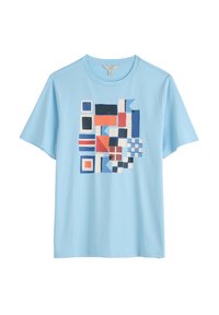 Světle modré bavlněné tričko s vícebarevným geometrickým vzorem v červené, modré a bílé. Kulatý výstřih a krátké rukávy.
