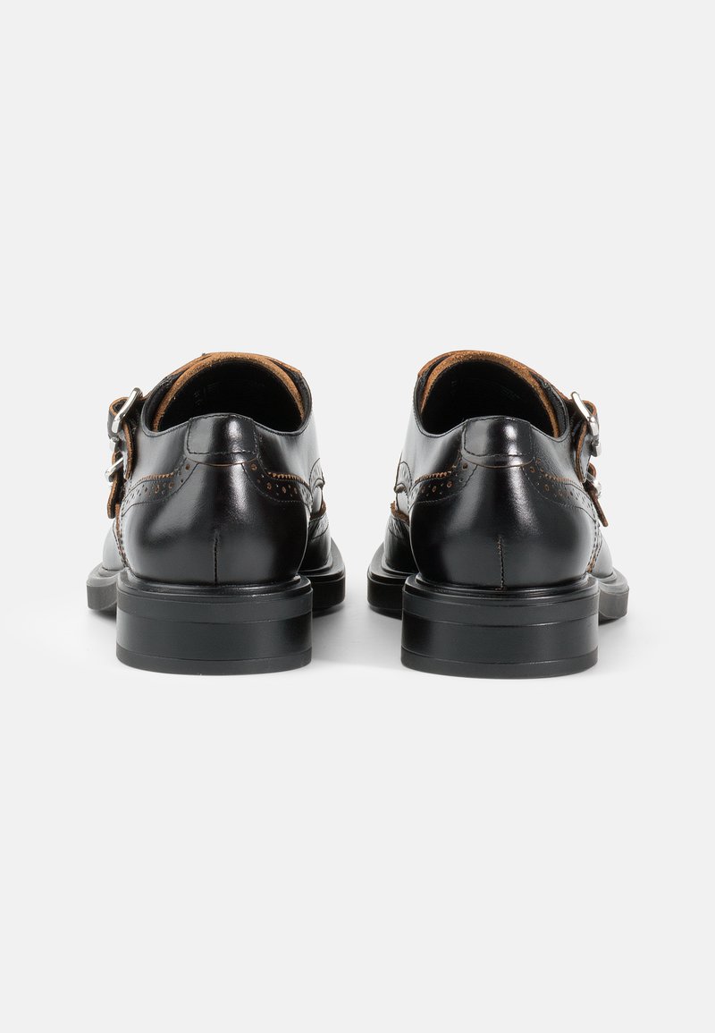 Scarpe in pelle nera con una finitura liscia, caratterizzate da una forma tondeggiante, un tacco basso e un dettaglio con fibbia regolabile di lato.