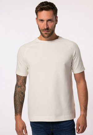 Camiseta de manga corta en color crema, hecha de una tela suave, con cuello redondo y un corte ligeramente holgado, con una textura lisa y sin patrones visibles.
