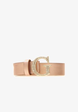 Ceinture en cuir beige avec une grande boucle dorée en forme de lettre "G" ornée de strass transparents, sur fond blanc.