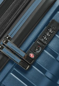 Maleta rígida azul con una superficie texturizada, dos cremalleras y un candado de combinación con el logo de la TSA para un acceso seguro.