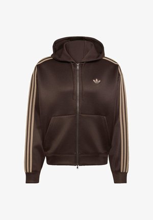 Sweat à capuche marron zippé avec trois bandes beige sur les manches, poches avant, capuche avec cordon de serrage et petit logo Adidas trèfle sur la poitrine.