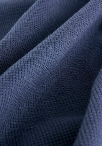 Tessuto blu navy con motivo a nido d'ape, caratterizzato da una superficie morbida, leggermente pelosa e un sottile splendore.