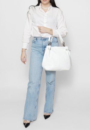 Borsa a mano in pelle bianca con doppi manici superiori, forma arrotondata, dettagli in metallo argentato, texture liscia e senza motivi visibili.